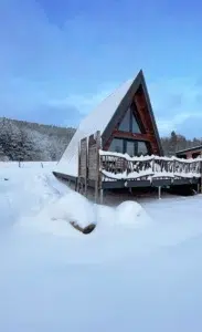 Chalet A-Frame Iorik sous la neige – location hiver près de Gérardmer Chalet A-Frame Iorik sous la neige en hiver, terrasse enneigée et forêt vosgienne, à 10 min de Gérardmer